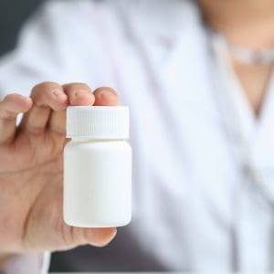 female doctor holding and showing a medicine bottle
