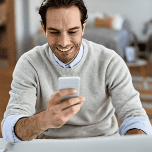 young-happy-businessman-working-home-text-messaging-mobile-phone